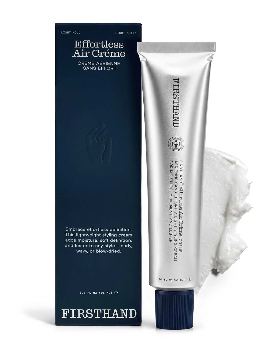 Firsthand Supply Effortless Air Crème silver tube beside its navy box and a smear of white styling cream on a white background.