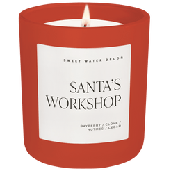 Candle with a red container and 'Santa's Workshop' label on a white background